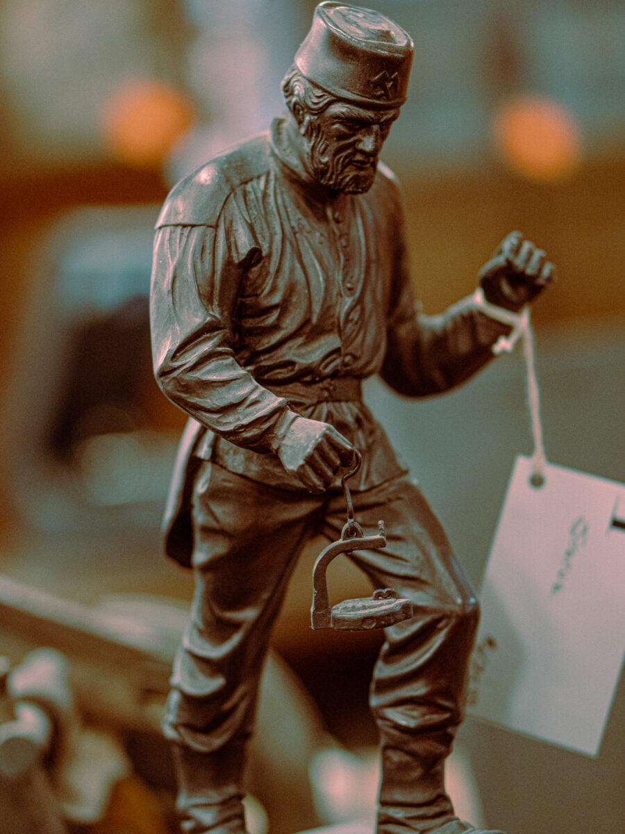 Antique bronze soldier statue with cap and lantern detail at Castle Antiques Haliburton Ontario.