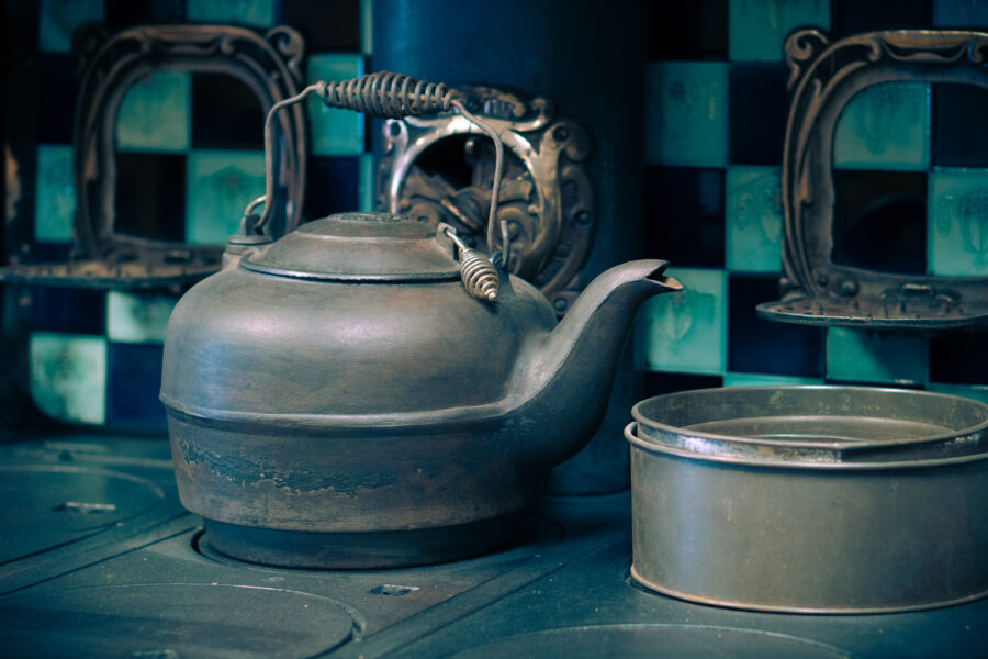 Antique cast iron kettle with matching cookware on vintage stove at Haliburton Ontario.