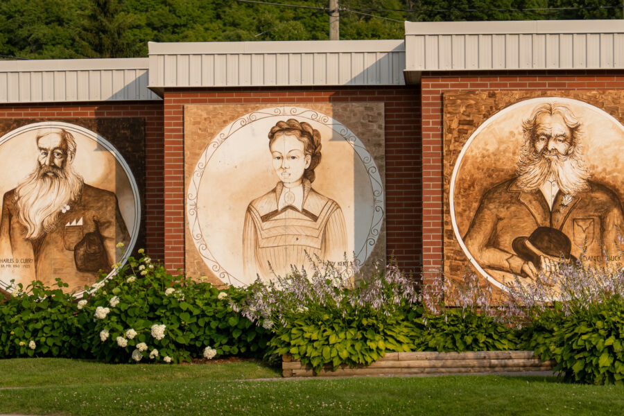 Brick wall with three historical portraits painted in sepia tones, Minden Ontario