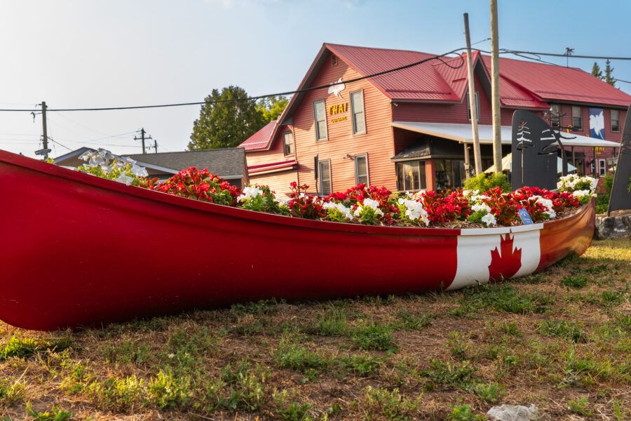 Red canoe painted with Canadian flag filled with flowers, Minden Ontario