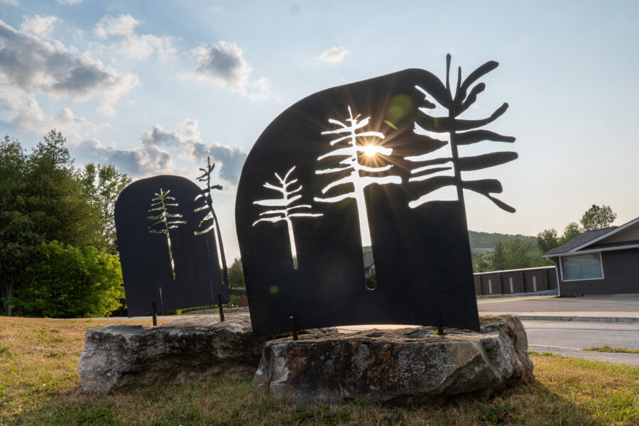 Metal tree silhouette sculptures with sun peeking through, Minden Ontario