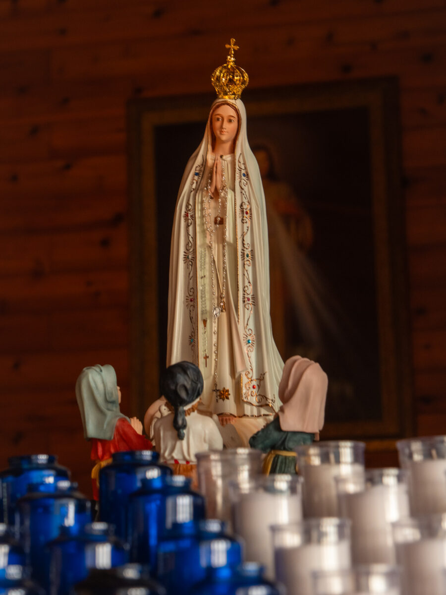 Statue of Our Lady of Fatima with crown and rosary, surrounded by figures of the three shepherd children, inside Our Lady of Fatima Church, Minden Ontario
