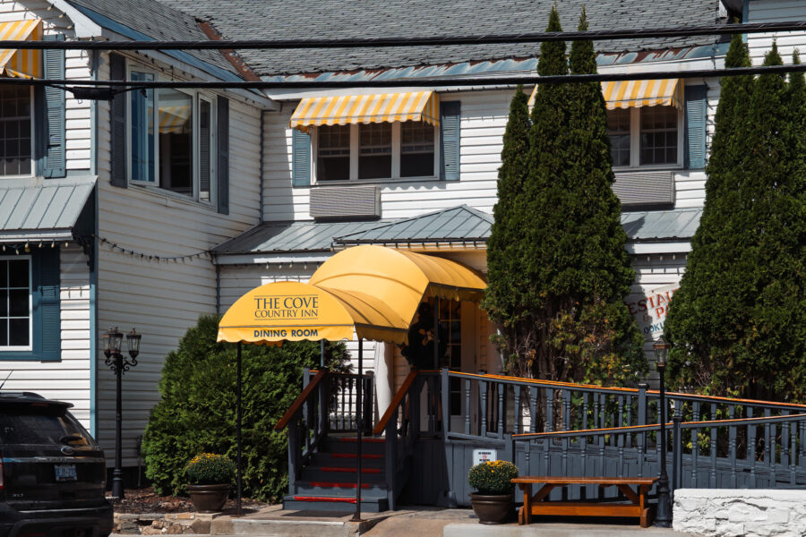 The Cove Country Inn dining room entrance with yellow canopy in Westport Ontario