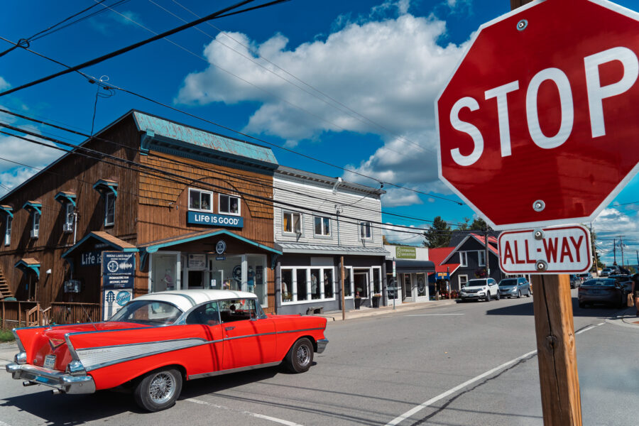 Classic red Chevrolet car driving through downtown Westport Ontario