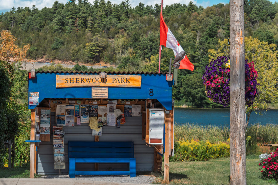 Sherwood Park community board and bus stop in Westport Ontario with Canadian flag