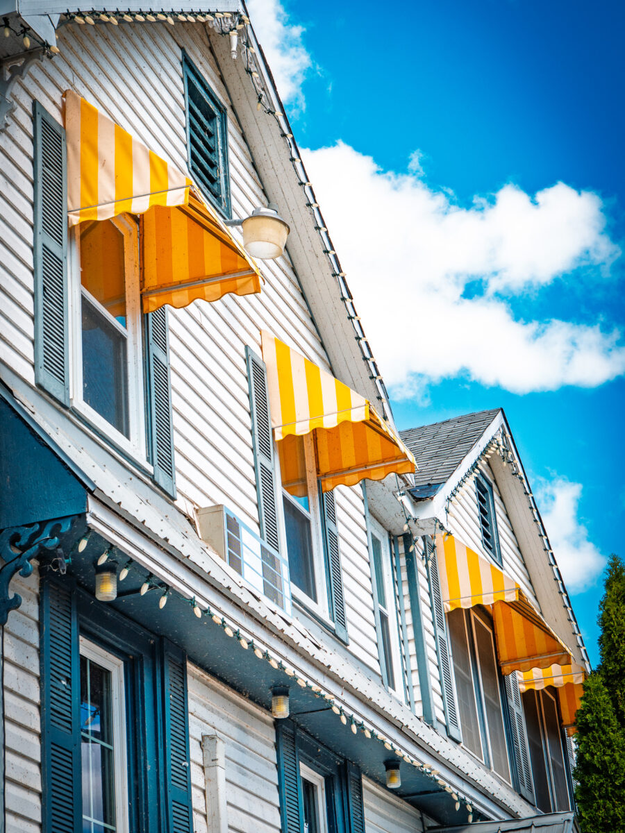 Yellow striped window awnings at The Cove Country Inn in Westport Ontario